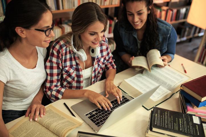 Female students around a laptop
