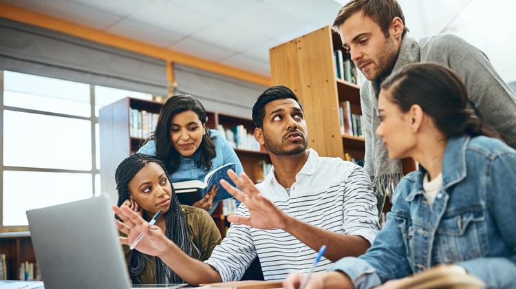 Diverse group of students chat work together on a project