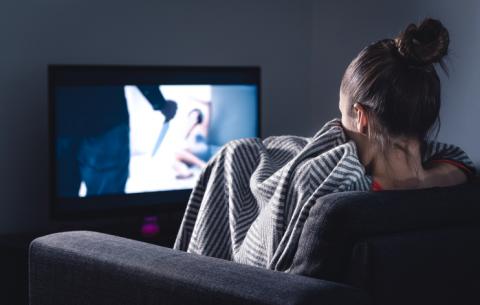 A woman watching a scary movie