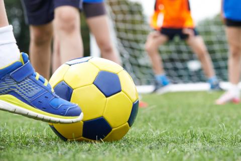 Football player kicking ball towards goal