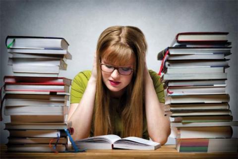 Girl studying surrounded by books